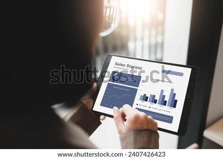 A close-up of an anonymous businesswoman analyzing statistical business reports on her tablet PC at the office.