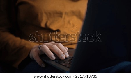 Close-up of an anonymous woman's hand using a laptop, representing digital interaction, technology, online activities and everyday computer use