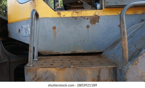 Close-up of the anti-slip access step on a heavy wheel loader leading to the operator cabin. 

The rugged metal footstep highlights safety features, industrial engineering, and equipment accessibility in heavy construction machinery. Ideal for concepts related to construction equipment, workplace safety, maintenance, heavy industry, mining, and engineering technology.