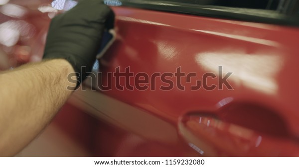 closeup applying\
ceramic coating on the red\
car