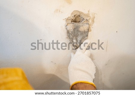 Close-up of applying a high-strength patching compound with a small blade, essential for high-quality wall restoration.