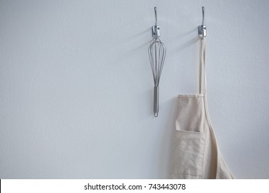 Close-up of apron and whisker hanging on hook - Powered by Shutterstock