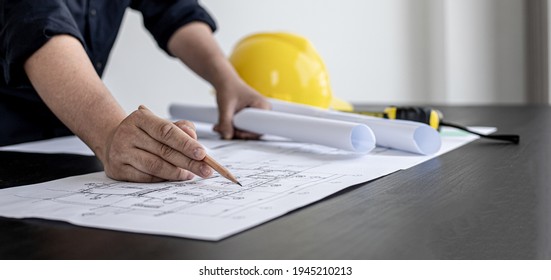 A Close-up, An Architect, A House Designer Holding A Pencil, Pointing To A House Plan To Examine The Design Plan Before Discussing The Details With The Client. Interior Design And Decoration Ideas.