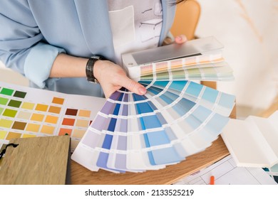 Close-up of architect woman choosing samples of wall paint. Interior designer looking at color swatch for creating project. House renovation, architecture and interior design concept. - Shutterstock ID 2133525219