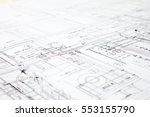 A close-up of an architectural blue print with black and white details, marked by measurements and construction and design details.