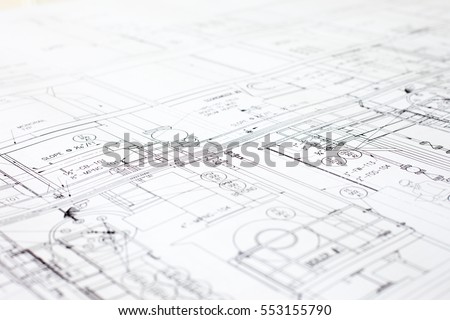 A close-up of an architectural blue print with black and white details, marked by measurements and construction and design details.