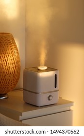 Closeup of aroma oil diffuser on the table at home, steam from the air humidifier, standing on the bedside table. Ultrasonic technology, increase in air humidity indoors, comfortable living conditions