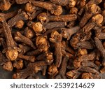 A close-up of aromatic cloves, highlighting the texture and rich color of the spice.