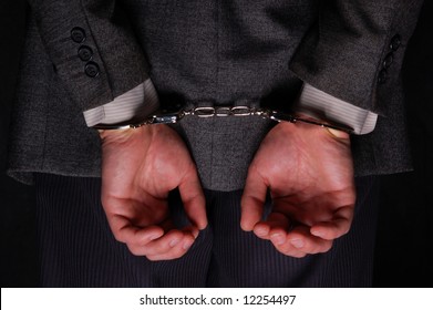 Close-up. Arrested businessman handcuffed hands at the back - Shutterstock ID 12254497