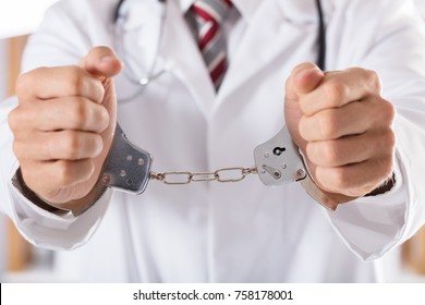 Close-up Of Arrested Doctor's Hand With Handcuffs
