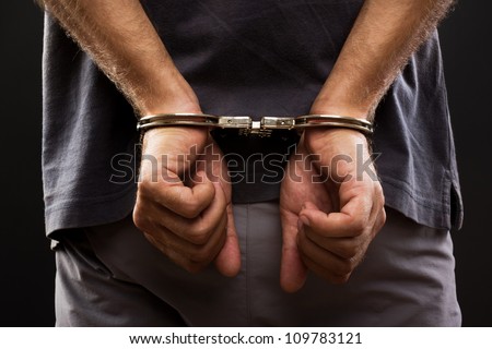 Close-up. Arrested man handcuffed hands at the back