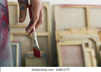 Closeup of an artist holding paintbrush