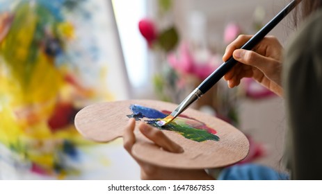 Closeup artist woman holding colour palette and mixed colour for acrylic painting project. - Powered by Shutterstock