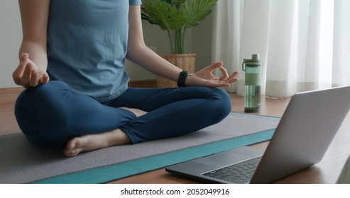 Close-up asia people woman enjoy study happy watch live video sit on sport mat at cozy home floor indoor easy zen class. Body calm life stress relax asana lotus pose in laptop self learn online media. - Shutterstock ID 2052049916