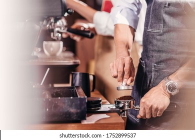 Closeup Asian Barista tamping the portafilter and preparing cup of coffee, espresso with latte or cappuccino for customer order in coffee shop, Small business owner and startup in coffee shop concept
 - Powered by Shutterstock