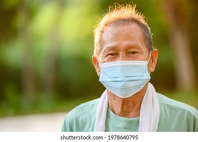 Close-up Of An Asian Elderly Man Or A Senior Man Wearing A Medical Mask During The Coronavirus And Influenza Pandemic. Prevention Of Viruses And Sickness In Outdoor Exercise And Walking In The Park.