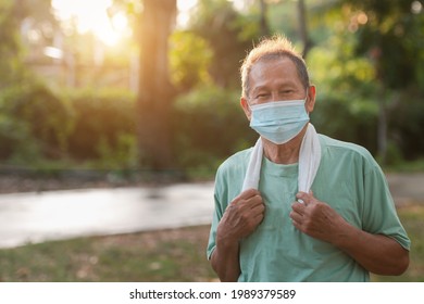 Close-up Of An Asian Elderly Man Or A Senior Man Wearing A Medical Mask During The Coronavirus And Influenza Pandemic. Prevention Of Viruses And Sickness In Outdoor Exercise And Walking In The Park.