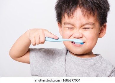 Closeup Asian Face, Little Cute Children Boy Use Hand Holds Toothbrush He Brushing Teeth Myself At Morning Every Day On White Background With Copy Space, Health Medical Care