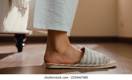 Close-up Asian girl foot step down on bed with white pajamas wear slipper walk to open curtain on window fresh peaceful morning light empty floor in bedroom at home. Female morning lifestyle concept. - Powered by Shutterstock