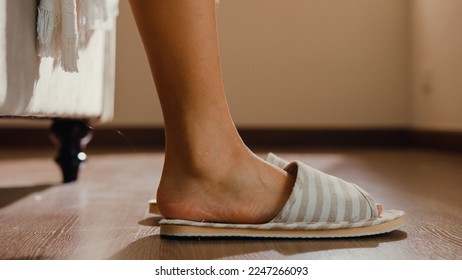 Close-up Asian girl foot step down on bed with white pajamas wear slipper walk to open curtain on window fresh peaceful morning light empty floor in bedroom at home. Female morning lifestyle concept. - Powered by Shutterstock