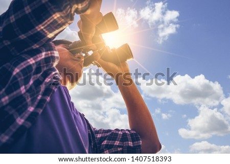 Close-up Of Asian man Hand Holding / looking / watching using Binoculars with copyspace, Technology Binoculars background concept