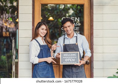 Closeup Asian partner Small business owner hands holding and showing the chalkboard with Welcome Open sign in front of coffee shop, startup with cafe store, installing open and close label concept - Powered by Shutterstock