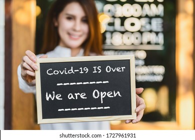 Closeup Asian Partner Small Business Owner Hands Holding And Showing The Chalkboard With Wording Covid-19 Is Over And We Are Open Sign In Front Of Coffee Shop,new Normal After Covid Gone, Coronavirus