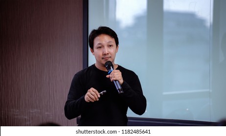 Closeup Asian Speaker Or Lecture With Casual Suit On The Stage In Front Of The Room Presenting With The Screen In The Conference Hall Or Seminar Meeting Room, Business And Education Concept