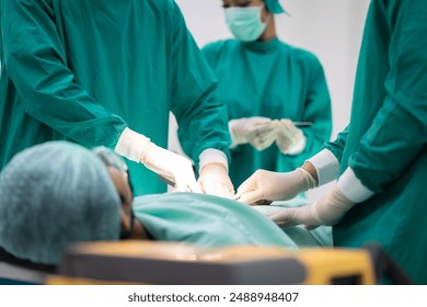 Close-up of Asian surgical team in green scrubs performing operation on patient. Focus on hands and instruments, precision, teamwork, and sterile environment in operating room in modern hospital - Powered by Shutterstock