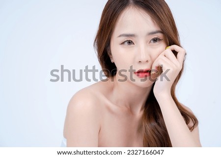 Close-up Asian woman with natural makeup touching her jaw. Skincare and Cosmetology concept with white background. 