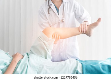 Close-up of Asian Woman physiotherapist checking and massaging the leg of patient in a physio room. Doctor and patient, Examination of the knee pain, old people and problem with her injuries.