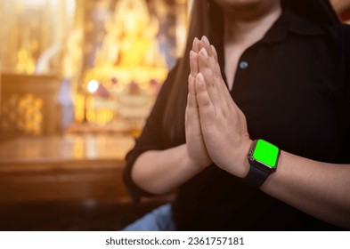 Close-up asian woman tourist Pay respect hand wearing smartwatch green screen with faith to Buddha statue in temple thailand belief in Buddhism - Powered by Shutterstock