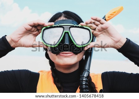 Close-up Asian woman wearing a black half-face snorkels after diving in the sea