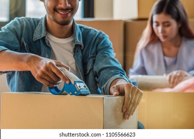 Closeup Asian Young Couple Packing Big Cardboard Box For Moving In New House, Moving And House Hunting Concept