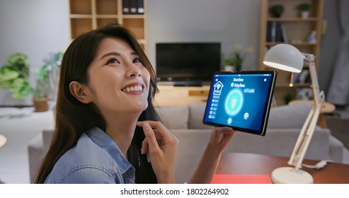 closeup of asian young woman using smart home app with voice assistant to control light turning on with tablet pc - Powered by Shutterstock