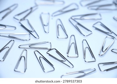 Close-up of assorted silver paper clips organized randomly on a white background.