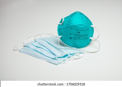 A closeup of an assortment of protective face masks. One N95 and three surgical masks.