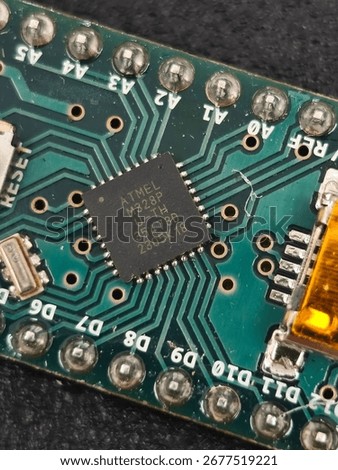 Close-up of ATmega328P microcontroller on custom PCB, showing reset switch, crystal oscillator and plated through-holes, concept electronics hardware