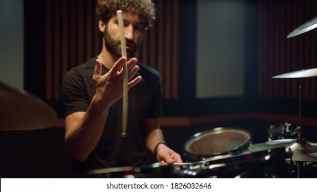 Closeup Attractive Man Hand Twirling Drumstick In Hand In Concert Hall. Band Drummer Preparing To Play Drum Kit In Recording Studio. Handsome Musician Turning Drumstick In Hand At Music Studio.