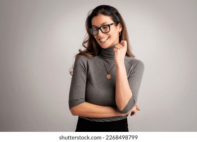 Close-up of an attractive mid aged woman cheerful smiling . Brunette haired female wearing eyewear and standing at isolated background. Copy space. 