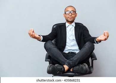 Closeup Of Attractive Young Man In Glasses Meditating On Office Chair