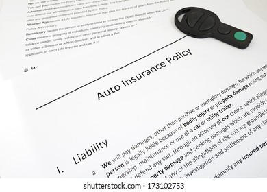 Closeup Of Auto Insurance Policy With Car Key                               