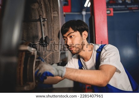 Close-up, Auto mechanic repairman using a socket wrench working engine repair in the garage, change spare part, check the mileage of the car, checking and maintenance service concept.