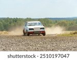 A close-up of an autocross racing car. Clouds of dust and sand burst out from under the wheels. Off-road racing.