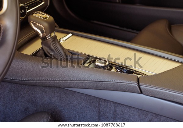Close-up of an automatic gear lever of an\
exotic luxury SUV vehicle and brown leather interior. Detail on a\
automatic gear shifter in a luxury\
car.