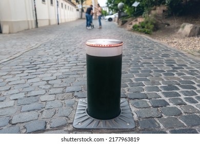 Close-up Automatic Metal Rising Smart Security Bollard Barrier For Safety Car Traffic In Old City Center Pedestrian Area. Walkway Street Electric Remote Access Control System On Pavement Road