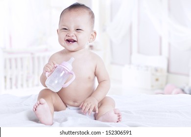Close-up of a baby with bottle at home