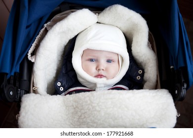 Closeup Baby Boy Is Lying In A Stroller In Winter Clothes