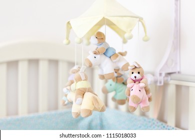 Close-up baby crib with musical animal mobile at nursery room. Hanged developing toy with plush fluffy animals. Happy parenting and childhood, expectation delivery of a child concept - Powered by Shutterstock