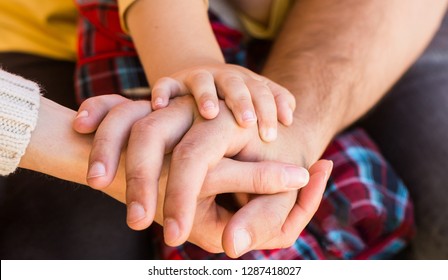 Closeup of baby hand into parents hands. Concept of unity, support, protection, happiness. Child hand closeup into parents. Hands of father, mother, keep hand little baby. 